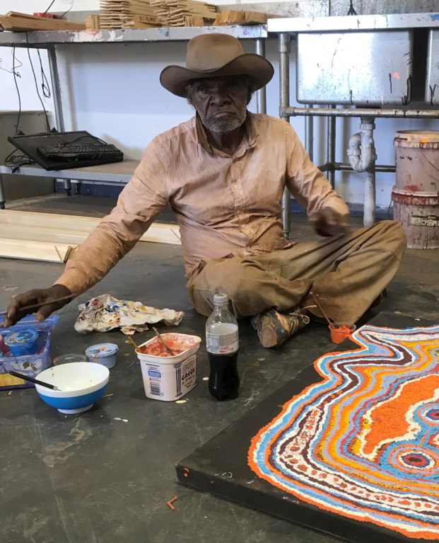 Jimmy Donegan sitting with paints and canvas