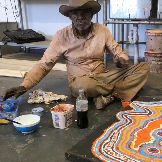 Jimmy Donegan sitting with paints and canvas
